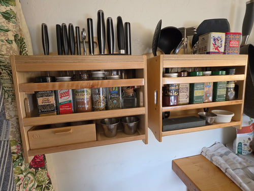 Two CUSTOMadera Cocina™ kitchen organizers wall mounted for storing cooking utensils, spices, seasonings, measuring cups, and everyday kitchen tools.