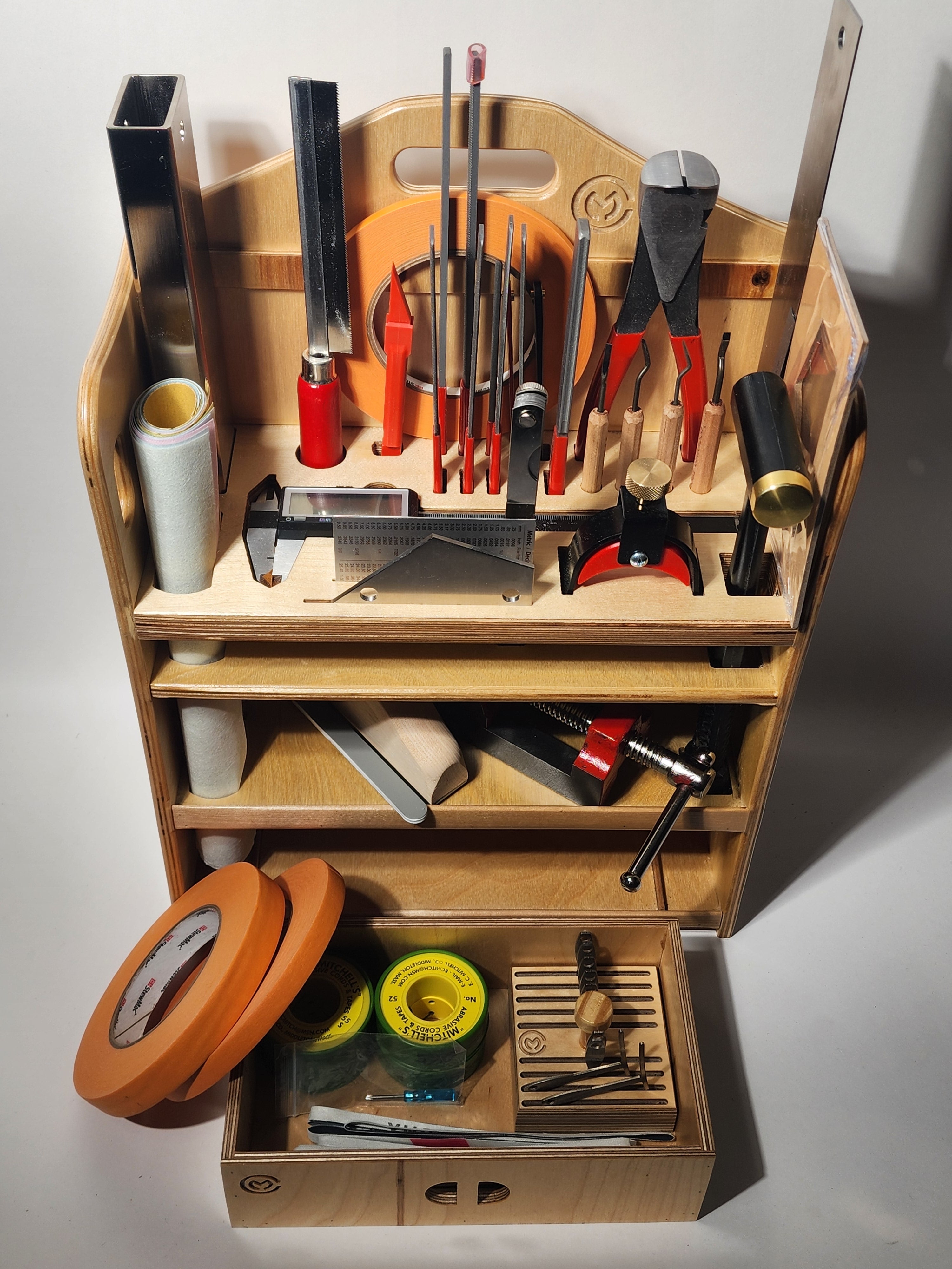 Handcrafted wooden luthier bench organizer holding guitar repair tools, setup accessories, and a removable gauge tray for organized bench storage.