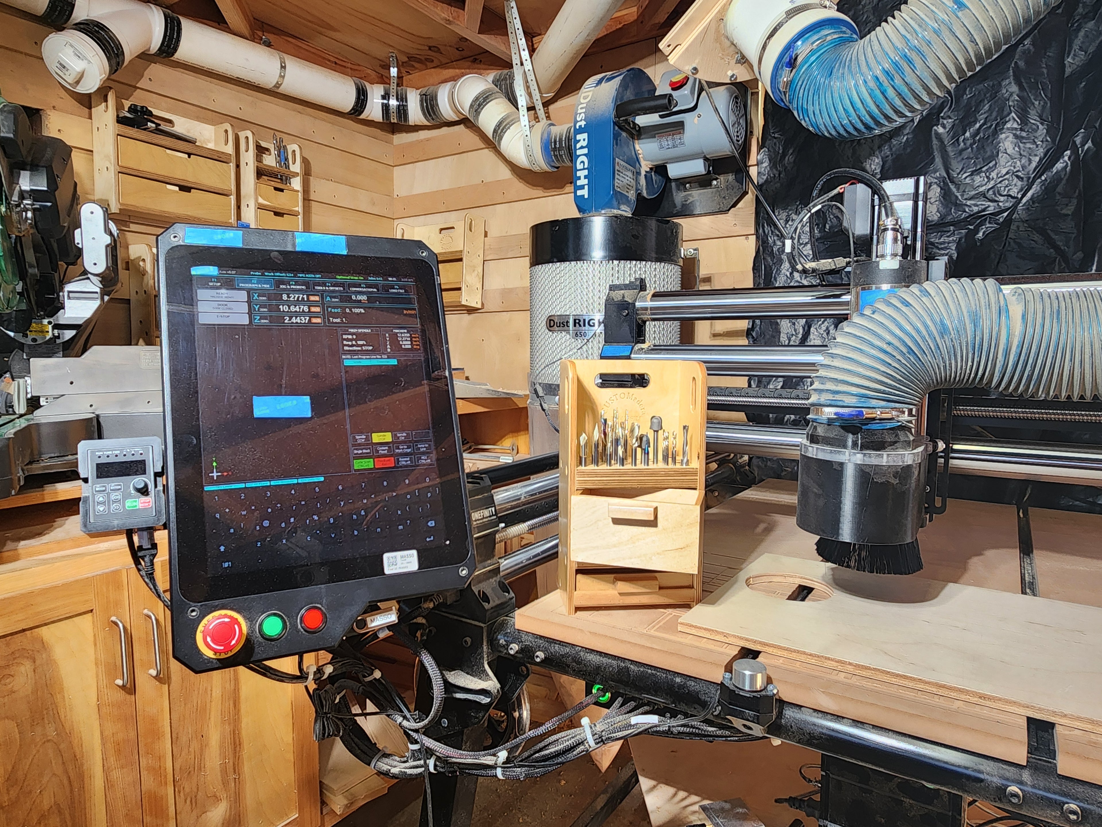 El Apoyo CNC™ Small CNC Bit Organizer shown in a working CNC shop near CNC equipment, with drill bits, router bits, and specialty cutters stored upright for quick access during woodworking, cabinetmaking, luthier, or maker workflows.