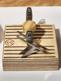Removable wooden El Calibre™ luthier gauge tray holding setup gauges and small guitar repair tools in slotted openings for organized precision bench work.
