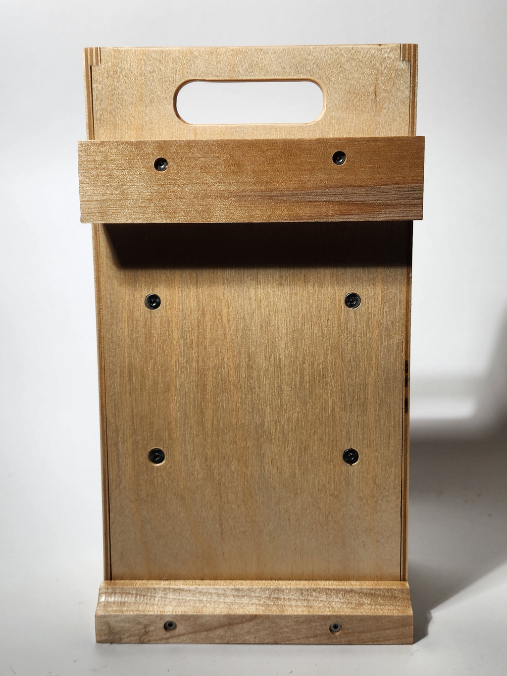 Back view of the El Compañero™ Small General Tool Organizer, showing the handcrafted layered wood construction, rear support panel, integrated carry handle opening, visible fasteners, and hardwood wall cleat area for storing the compact wooden caddy when not in use.