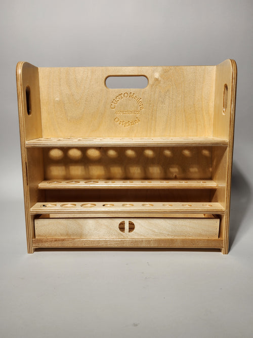 Front view of the El Pilar™ Large General Tool Organizer, a handcrafted wooden caddy with vertical tool storage, stepped shelves, integrated carry handle openings, CUSTOMadera branding, and a lower drawer for organized workshop storage.