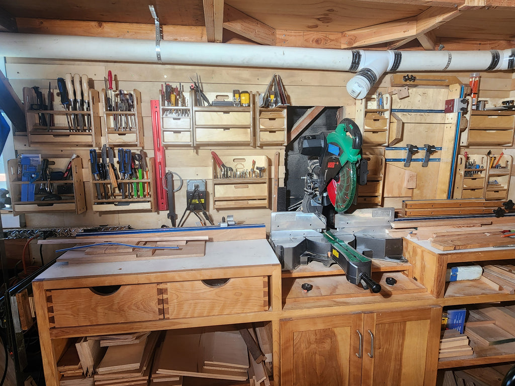 El Pilar™ Large General Tool Organizer shown mounted on a workshop wall using the wall cleat system, surrounded by woodworking tools, workbenches, storage cabinets, and shop equipment in a functional garage shop workspace.
