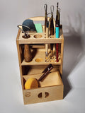 Handcrafted wooden pottery tool organizer holding loop tools, ribs, trimming tools, brushes, and a sponge with a smooth-sliding drawer open.
