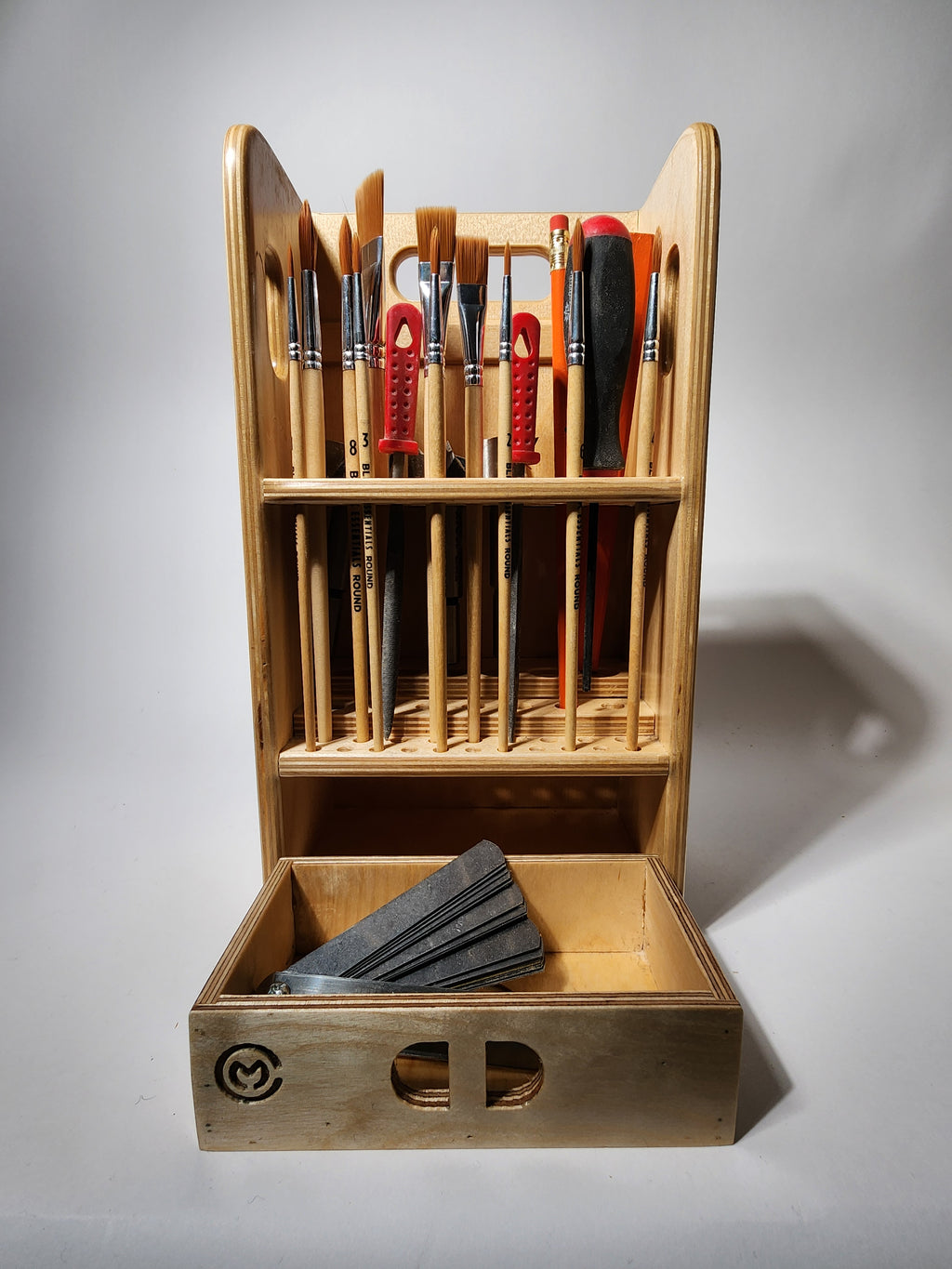 Small General Tool Organizer (El Compañero™ Wooden Caddy) handcrafted from layered wood, shown holding assorted brushes, files, picks, and small hand tools upright in precision-drilled vertical storage holes, with a smooth lower drawer and integrated carry handles.